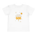 In the Beginning God lettering with smiling stars, a sun and a small gold cross on a White toddler T-Shirt