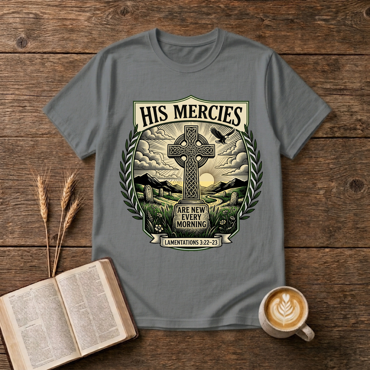 Monochrome Celtic cross against a dawn sky framed by laurel leaves with His Mercies on a Graphite Heather unisex T-Shirt