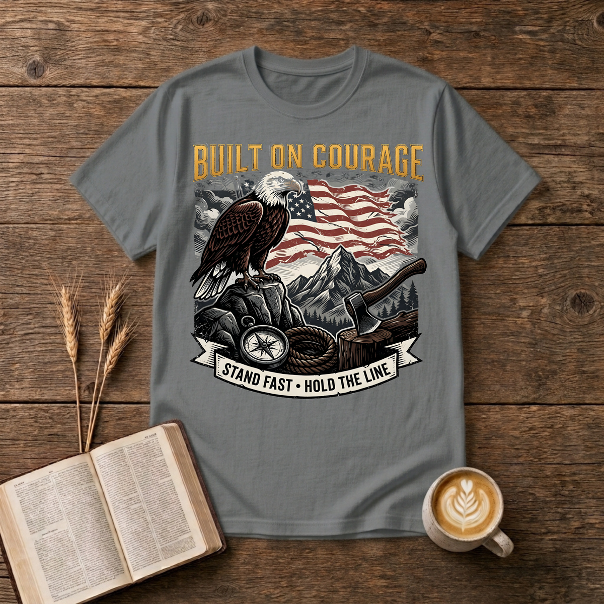 Built on Courage design of a stoic eagle before mountains with a faded American flag on a Graphite Heather unisex T-Shirt