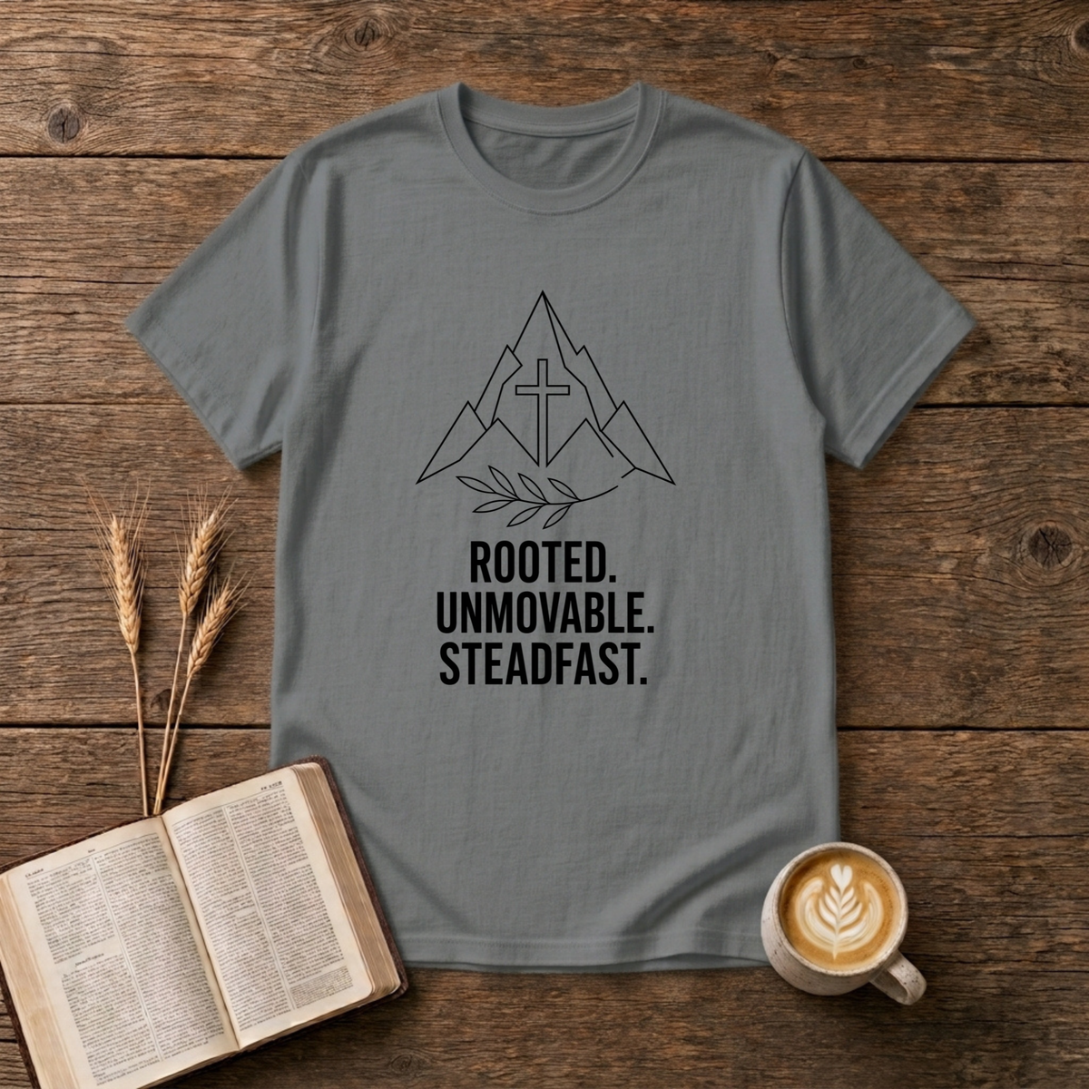 Minimalist mountain outline with centered cross and laurel sprig, Rooted Unmovable Steadfast on a Graphite Heather T-Shirt