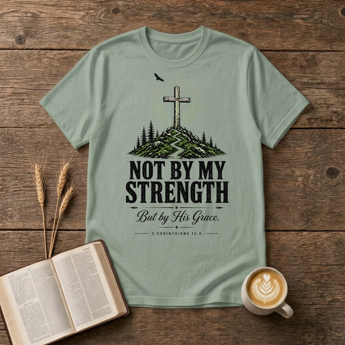 Hand-drawn cross on a rugged hill surrounded by pines with a lone bird on a Sage unisex T-Shirt