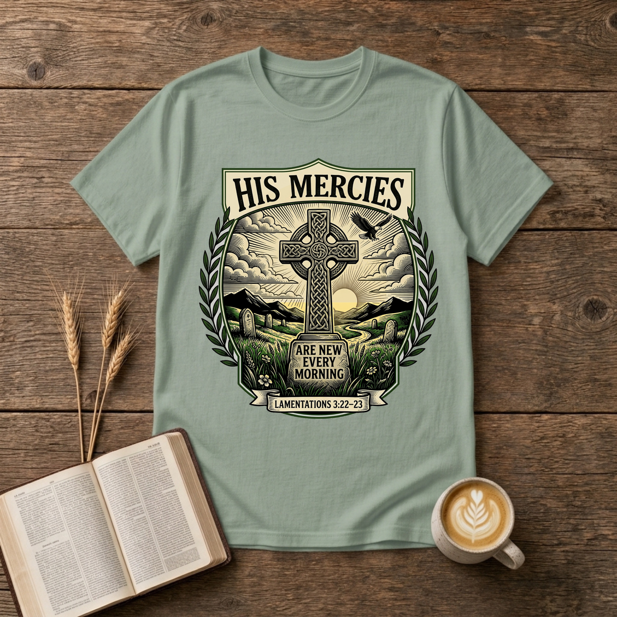 Monochrome Celtic cross against a dawn sky framed by laurel leaves with His Mercies on a Sage unisex T-Shirt