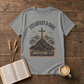 Steadfast and Sure lettering above a cross atop a rocky peak on a Sport Grey unisex T-Shirt