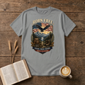 Born Free design of a soaring eagle over a waving American flag and pine-lined mountains on a Sport Grey unisex T-Shirt