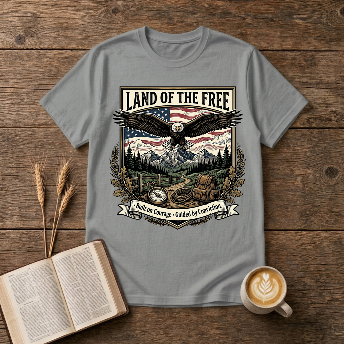 Monochrome eagle soaring above mountains and pines with a Land of the Free banner on a Sport Grey unisex T-Shirt