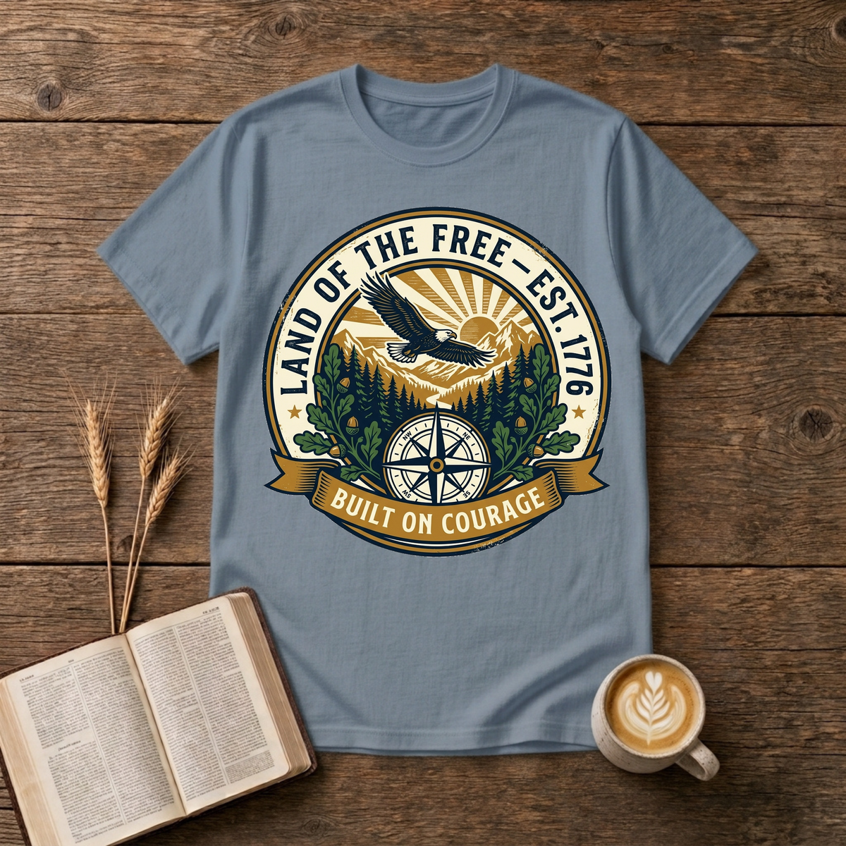 Faded emblem of an eagle gliding above pine silhouettes with a sunrise compass on a Stone Blue unisex T-Shirt
