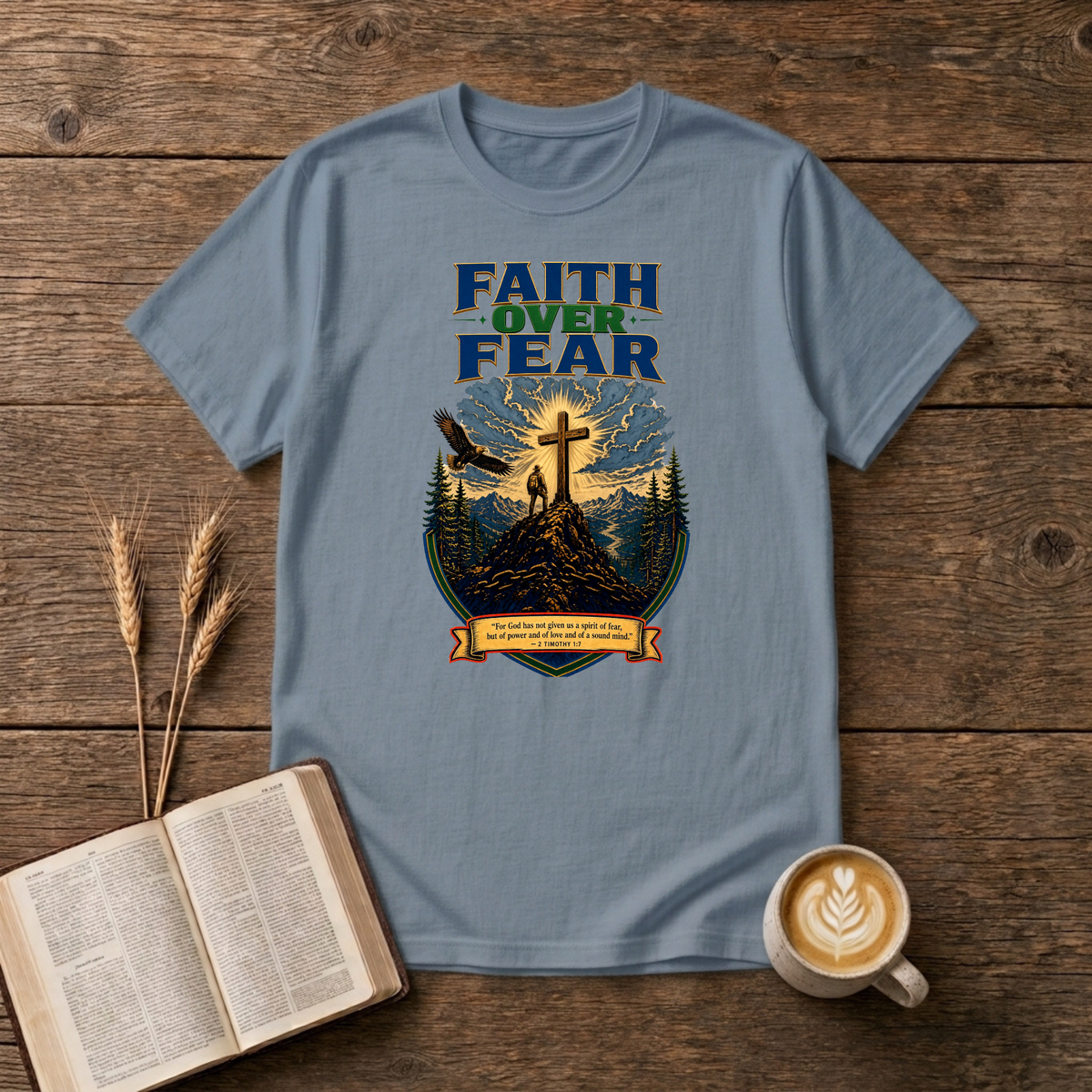 Faith Over Fear lettering over a mountain silhouette, pines and glowing cross on a Stone Blue unisex T-Shirt