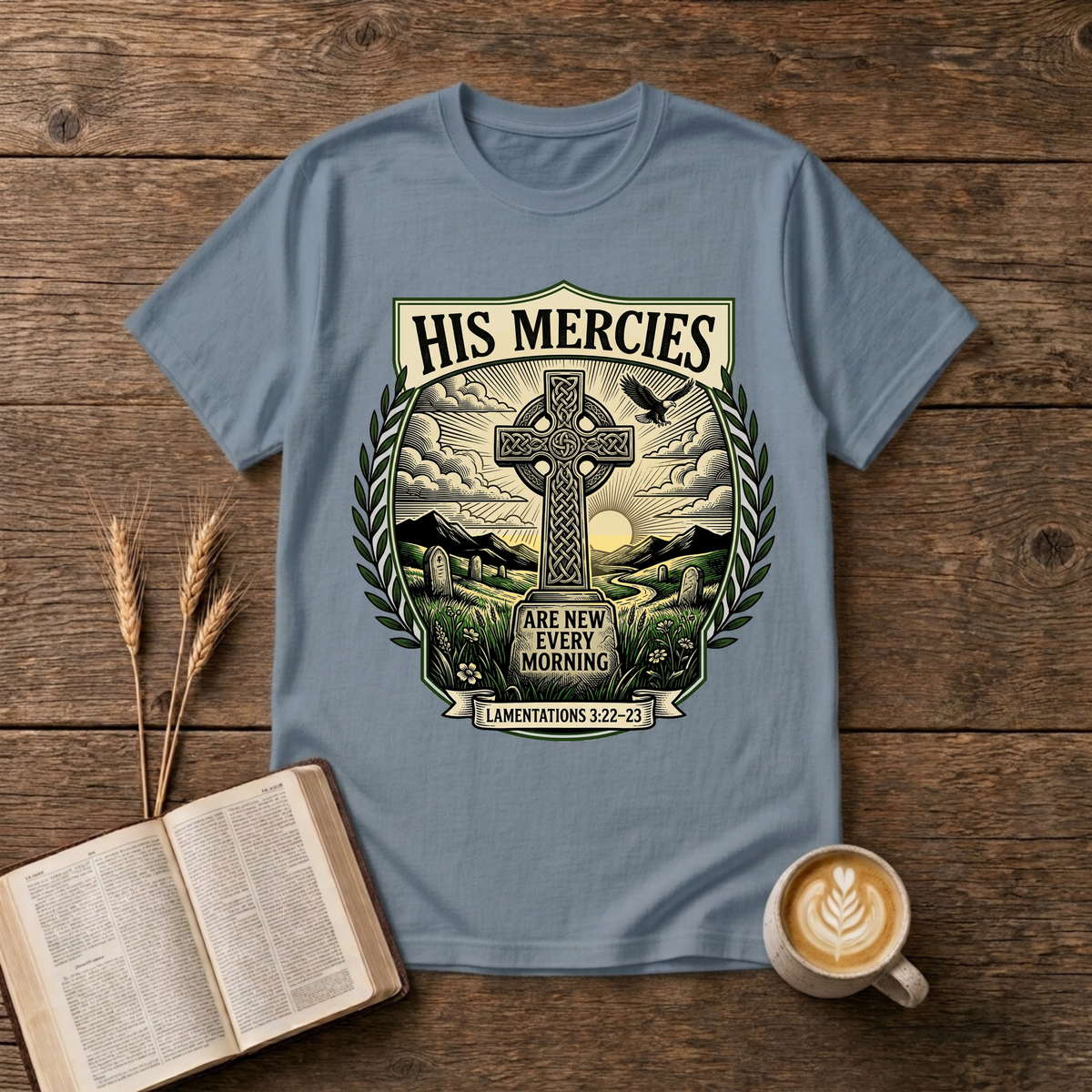 Monochrome Celtic cross against a dawn sky framed by laurel leaves with His Mercies on a Stone Blue unisex T-Shirt
