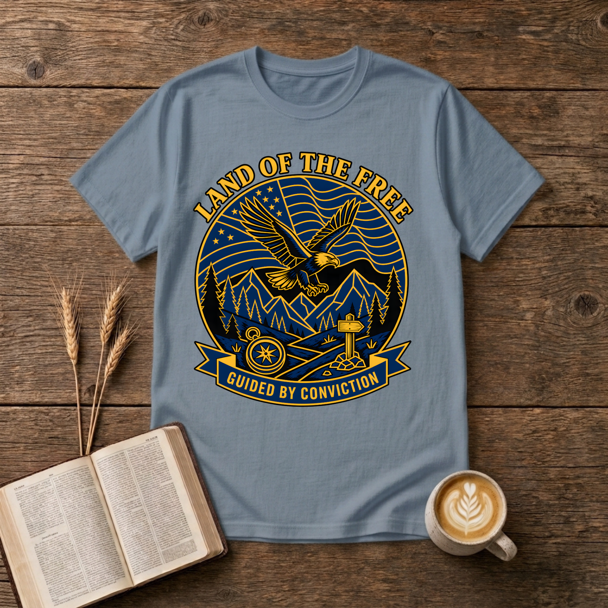 Bold monochrome emblem of an eagle in flight above mountains on a Stone Blue unisex T-Shirt