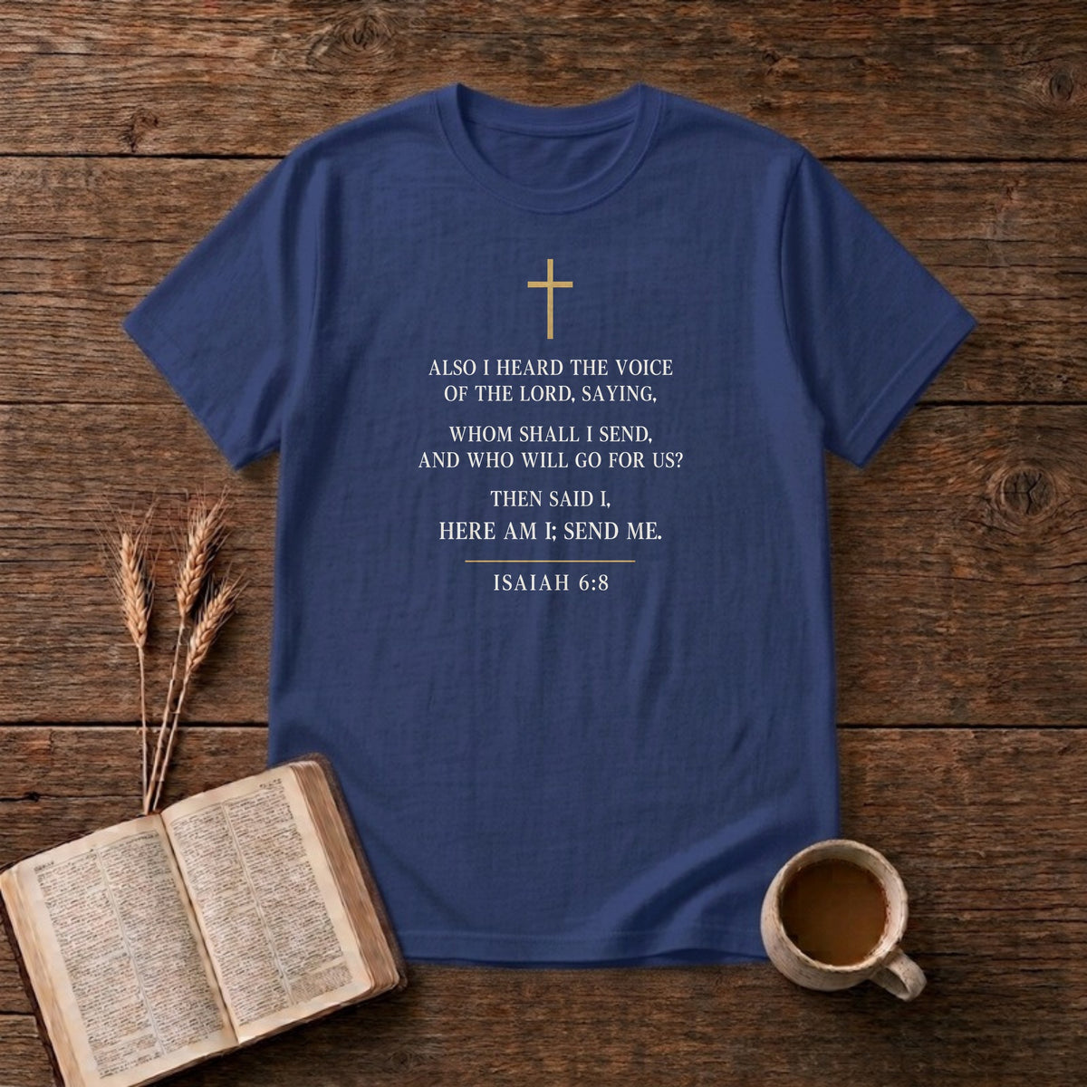 Isaiah 6:8 KJV verse "Also I heard the voice of the Lord, saying, Whom shall I send, and who will go for us? Then said I, Here am I; send me." in cream engraved type under a small gold cross on a Metro Blue unisex T-shirt