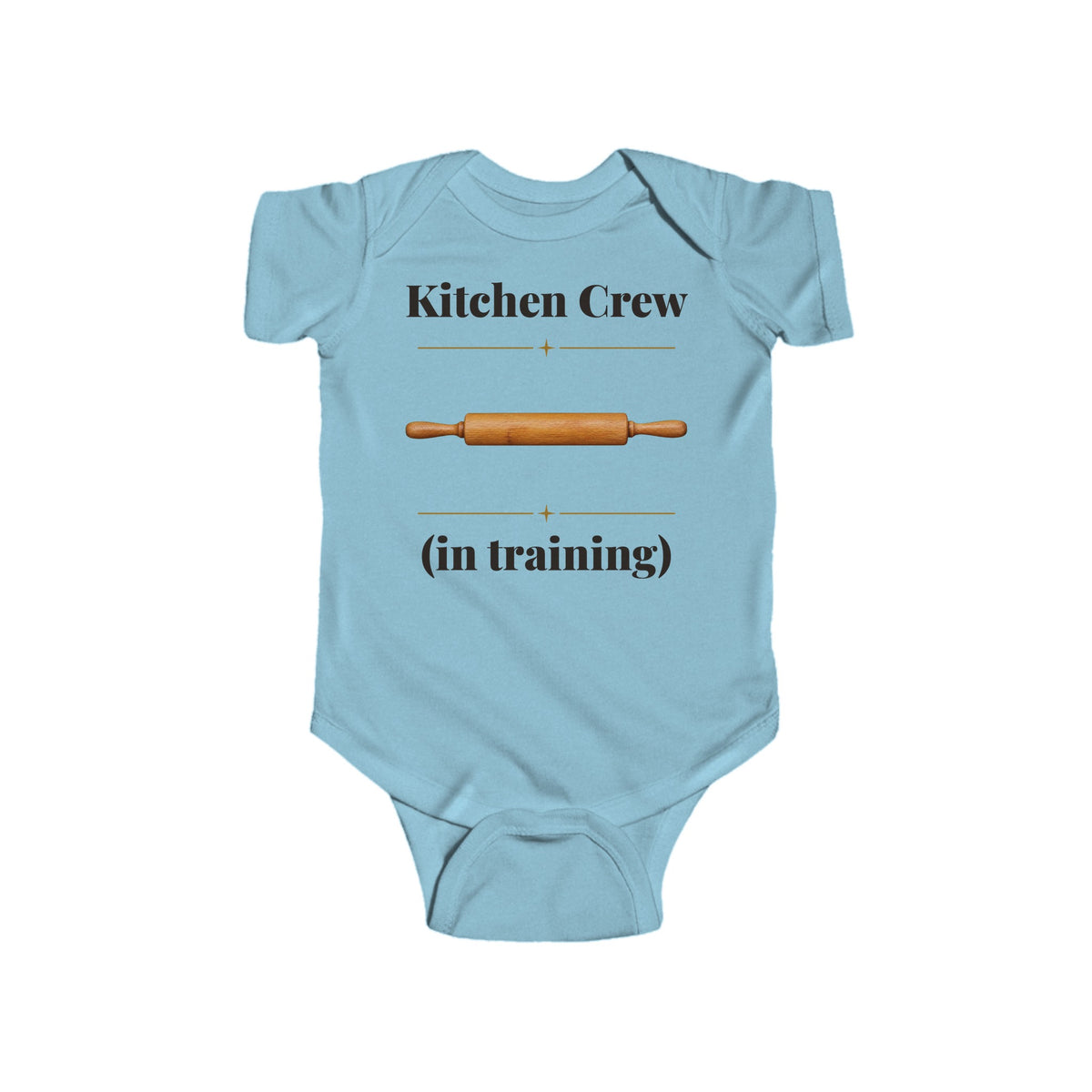 Kitchen Crew in Training baby bodysuit in Light Blue on a wood table with a knit blanket, wooden rattle and open Bible