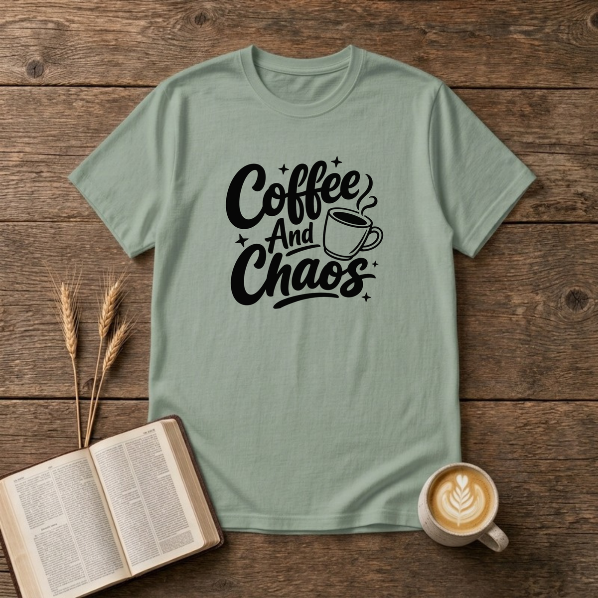 Coffee and Chaos design with black script lettering beside a steaming coffee cup on a Sage unisex T-Shirt
