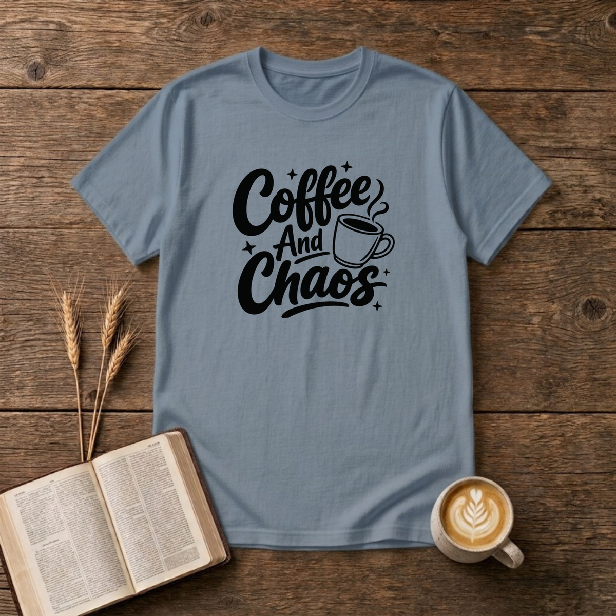 Coffee and Chaos design with black script lettering beside a steaming coffee cup on a Stone Blue unisex T-Shirt