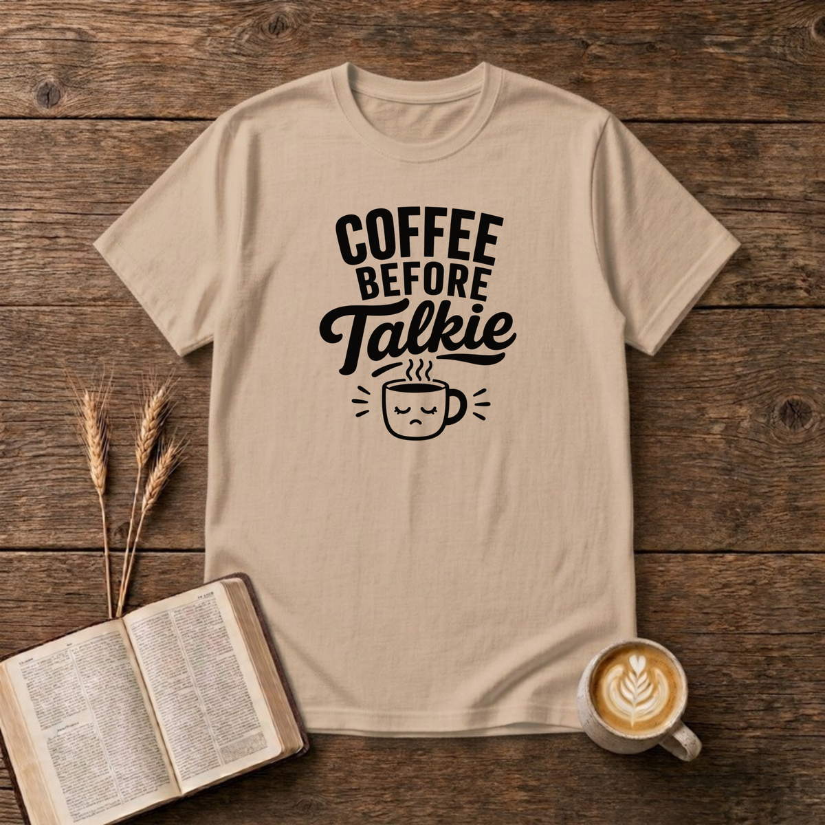 Coffee Before Talkie design with black lettering above a sleepy frowning coffee cup on a Natural unisex T-Shirt