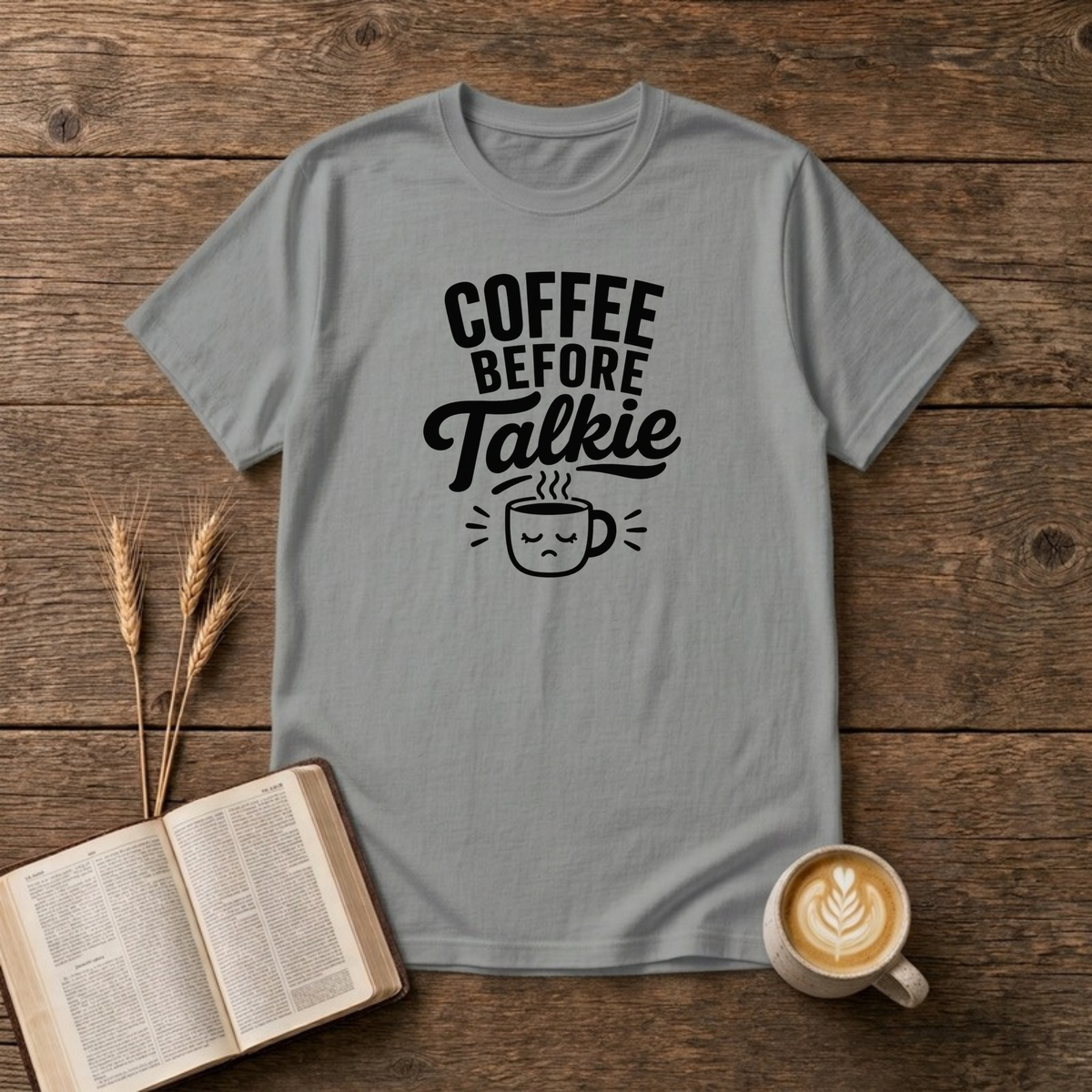 Coffee Before Talkie design with black lettering above a sleepy frowning coffee cup on a Sport Grey unisex T-Shirt