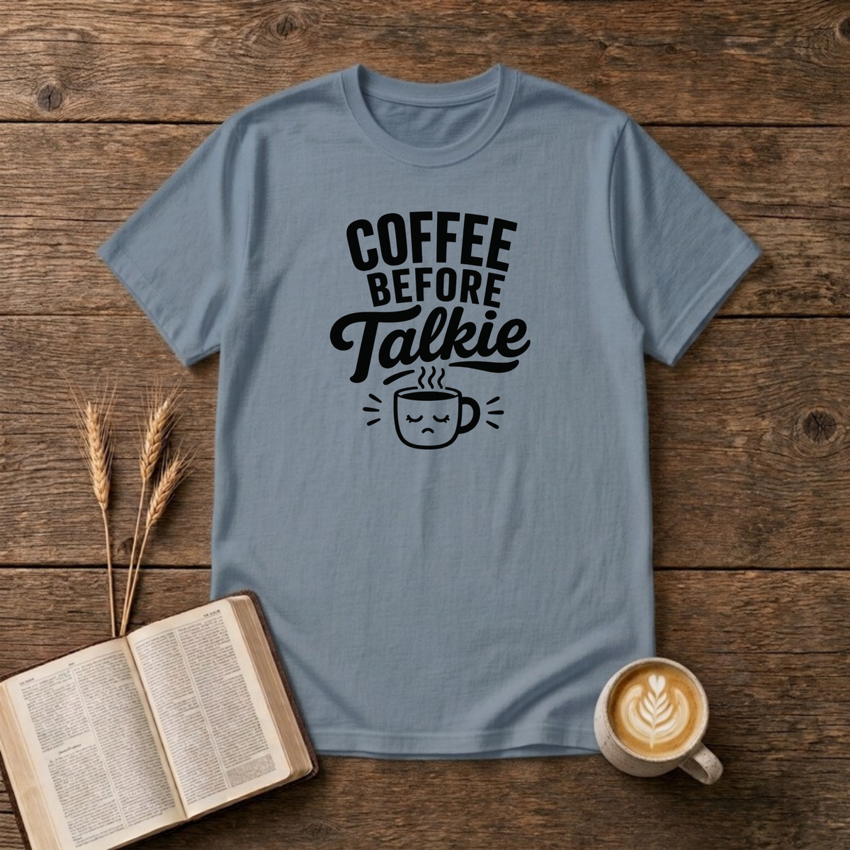 Coffee Before Talkie design with black lettering above a sleepy frowning coffee cup on a Stone Blue unisex T-Shirt