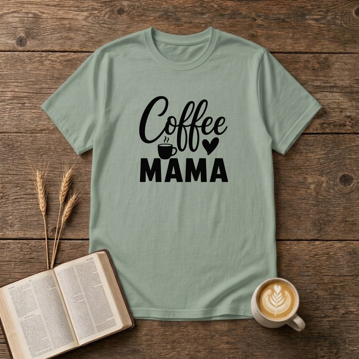 Coffee Mama design with black script and block lettering with a small coffee mug and a heart on a Sage unisex T-Shirt