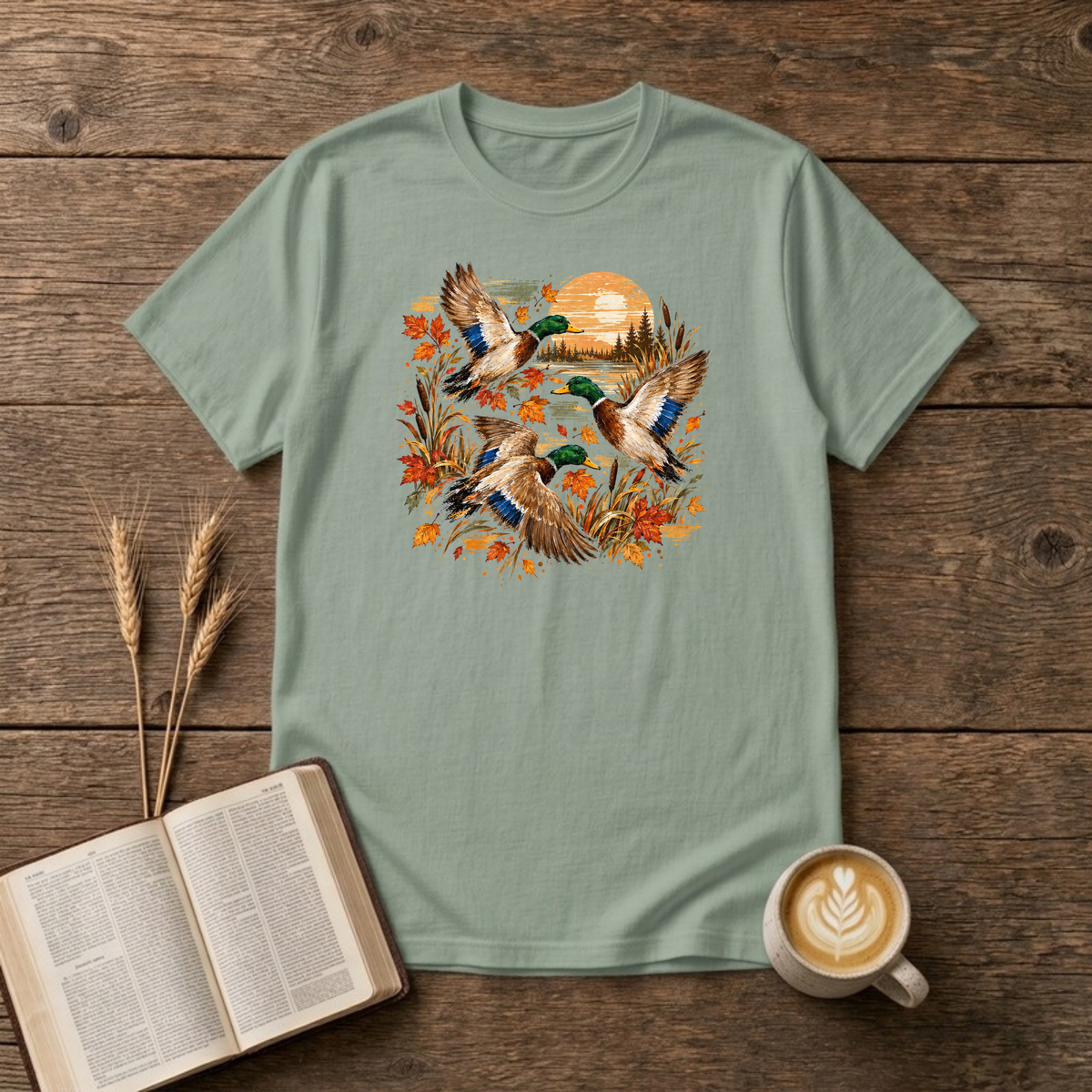 Ducks at Sunset design with three mallard ducks in flight over autumn leaves, golden reeds and a sunset on a Sage unisex T-Shirt