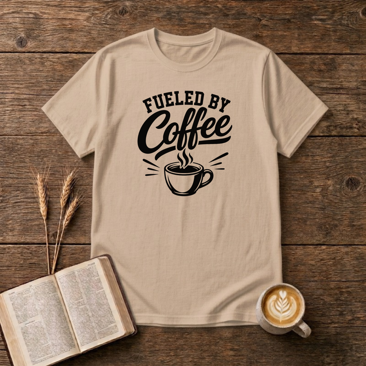 Fueled by Coffee design with black arched lettering above a steaming cup of coffee on a Natural unisex T-Shirt