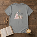 A Savior Is Born watercolor nativity design of Mary kneeling beside baby Jesus in the manger under a gold star on a Sport Grey unisex T-Shirt