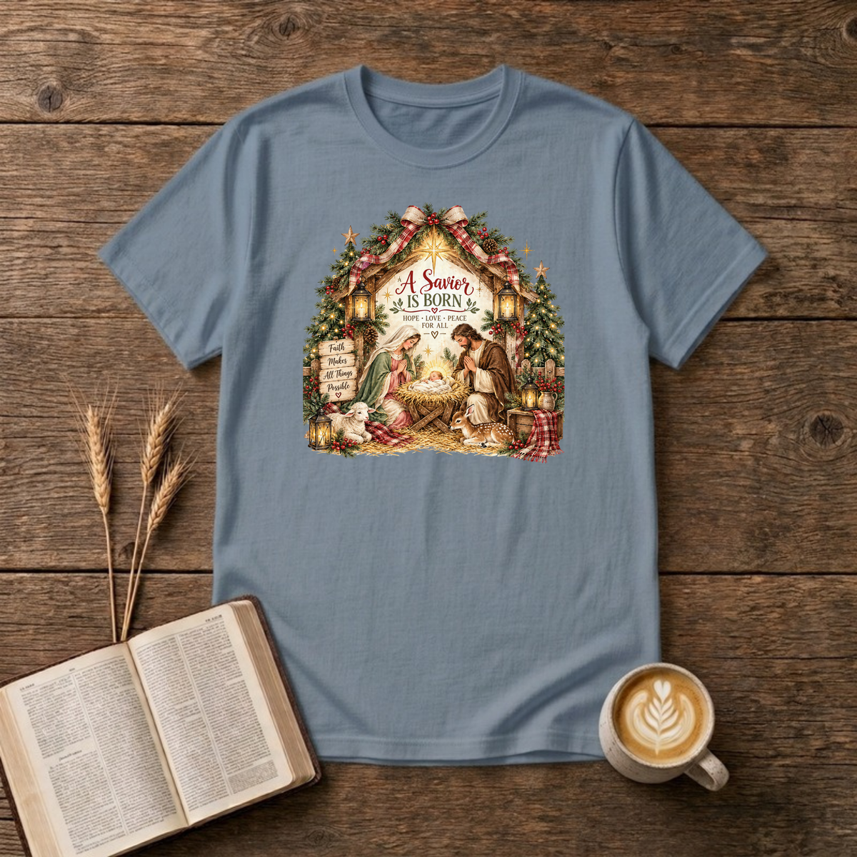 A Savior Is Born manger nativity design of Mary, Joseph and baby Jesus in a wooden stable with a lamb, lanterns and Christmas trees on a Stone Blue unisex T-Shirt