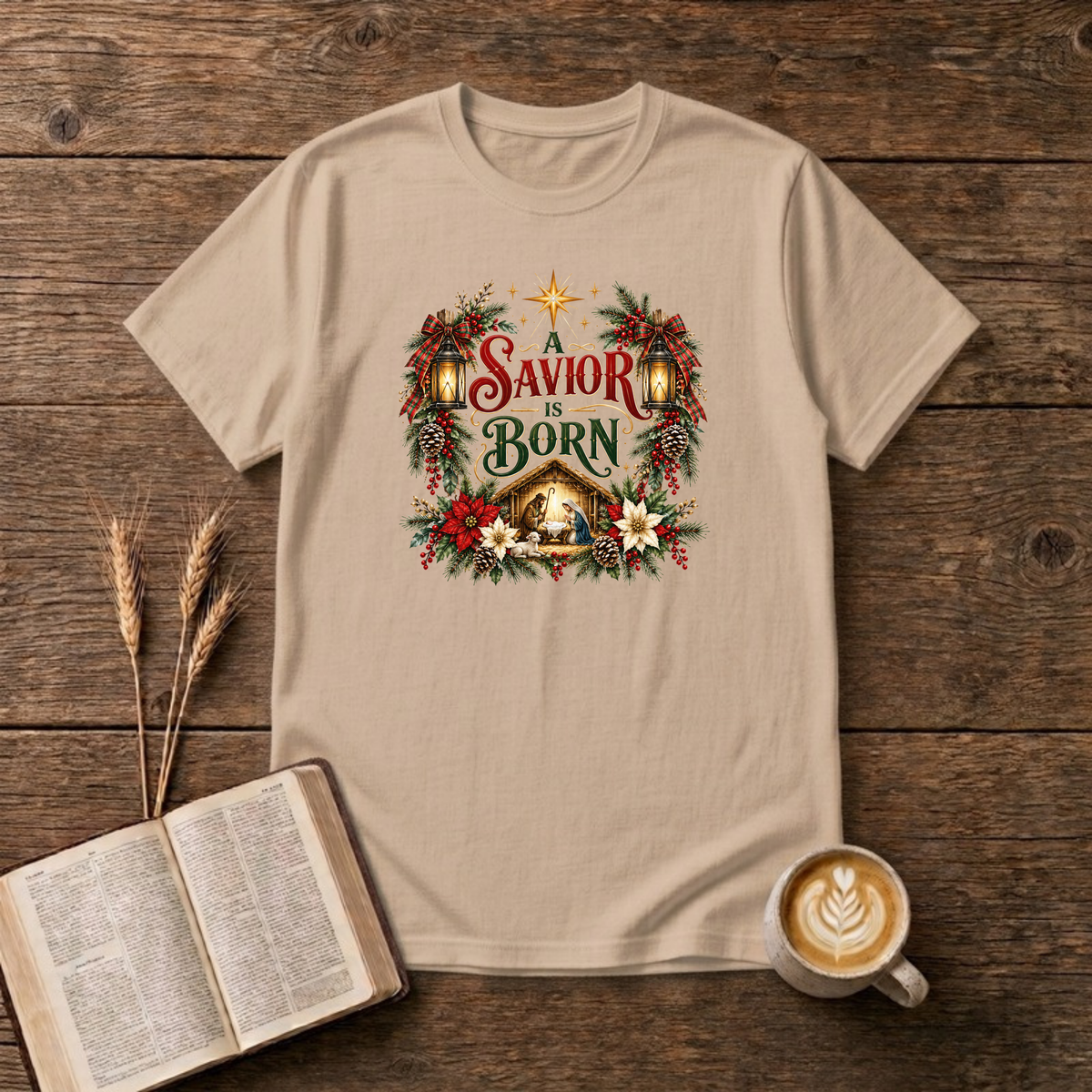 A Savior Is Born nativity wreath design with red and white poinsettias, holly and a lit stable scene on a Natural unisex T-Shirt