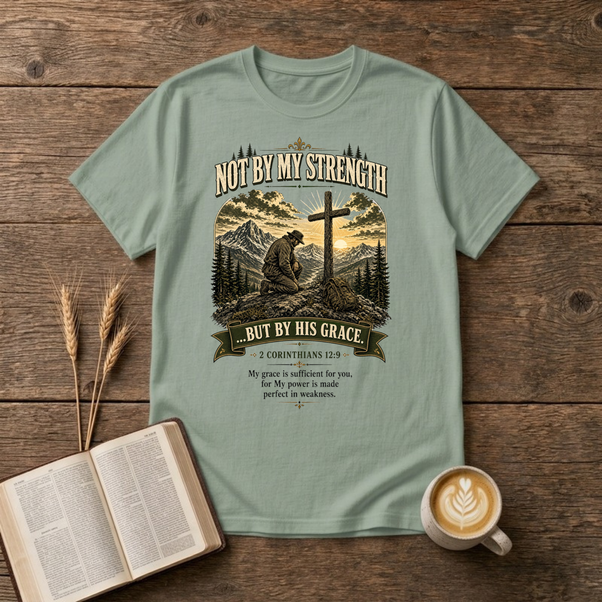 Mountain scene with a wooden cross and the words Not By My Strength on a Sage unisex T-Shirt