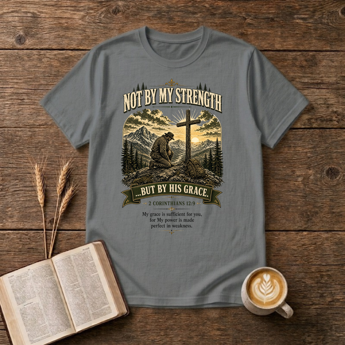 Mountain scene with a wooden cross and the words Not By My Strength on a Graphite Heather unisex T-Shirt