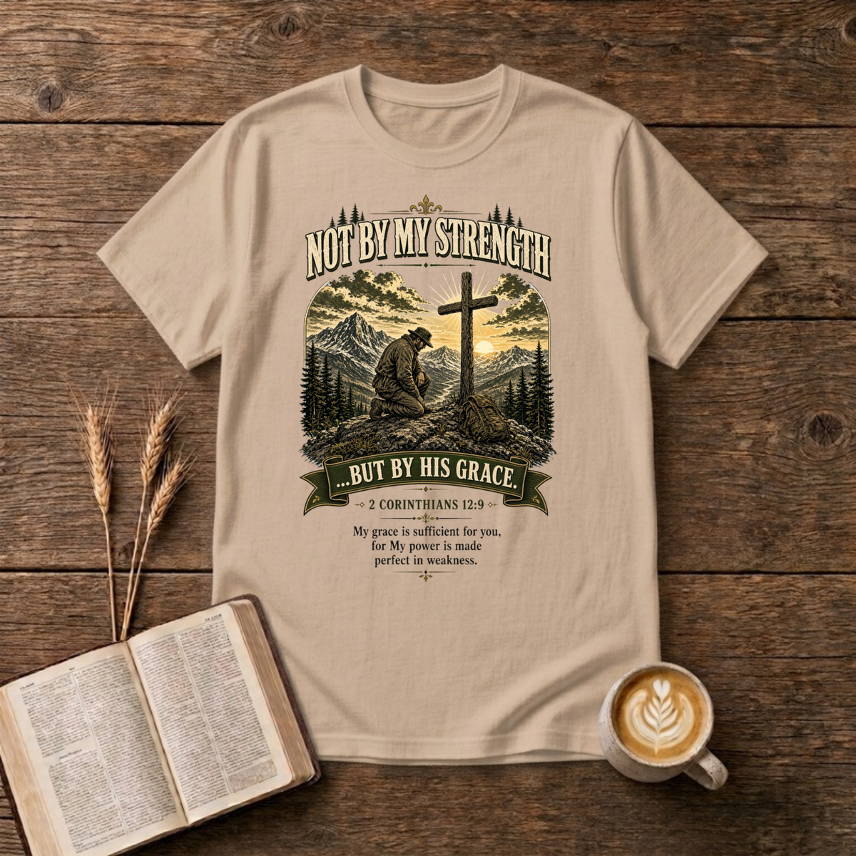 Mountain scene with a wooden cross and the words Not By My Strength on a Natural unisex T-Shirt