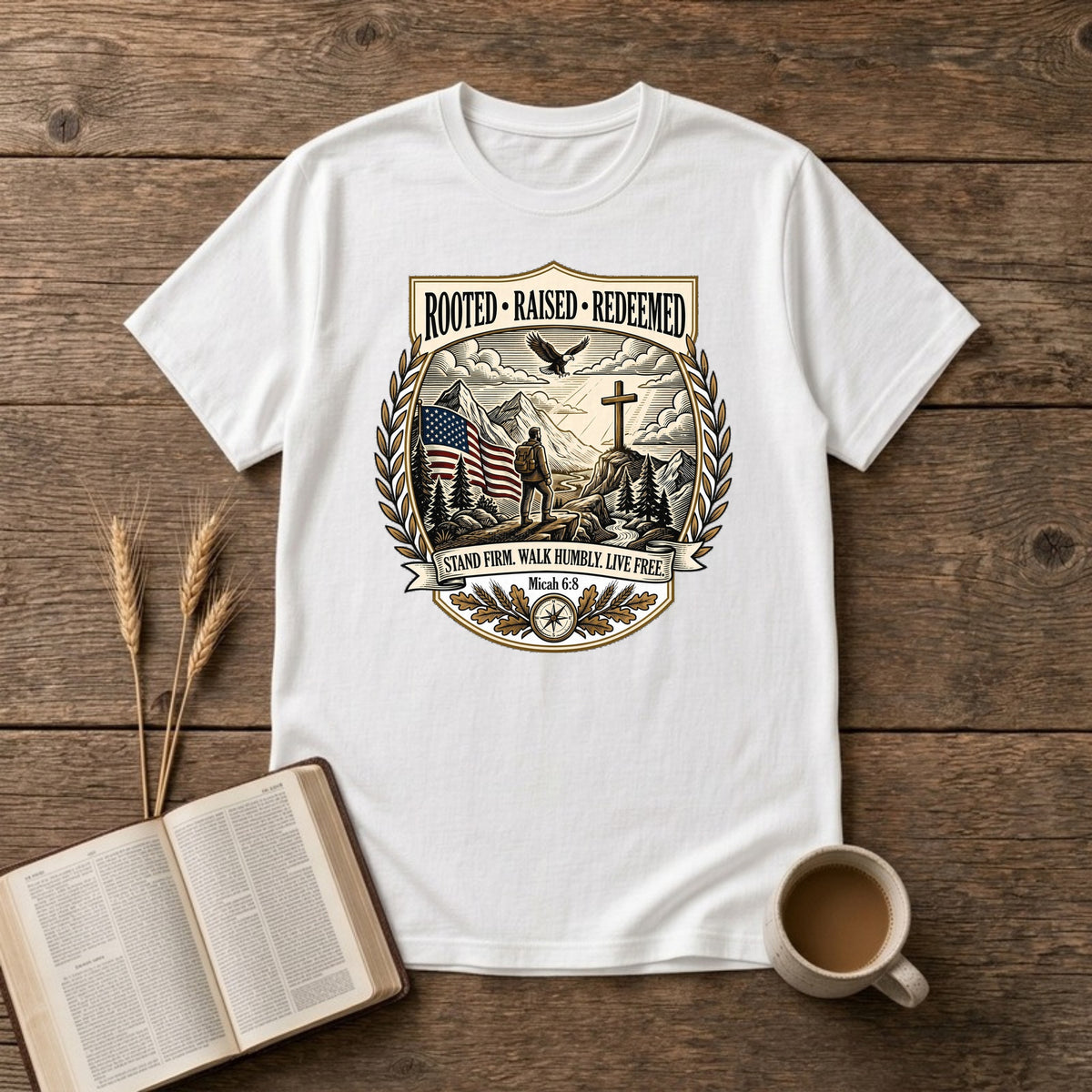 Rooted. Raised. Redeemed. crest badge with a hiker, cross, American flag, eagle and laurel frame on a White unisex T-shirt