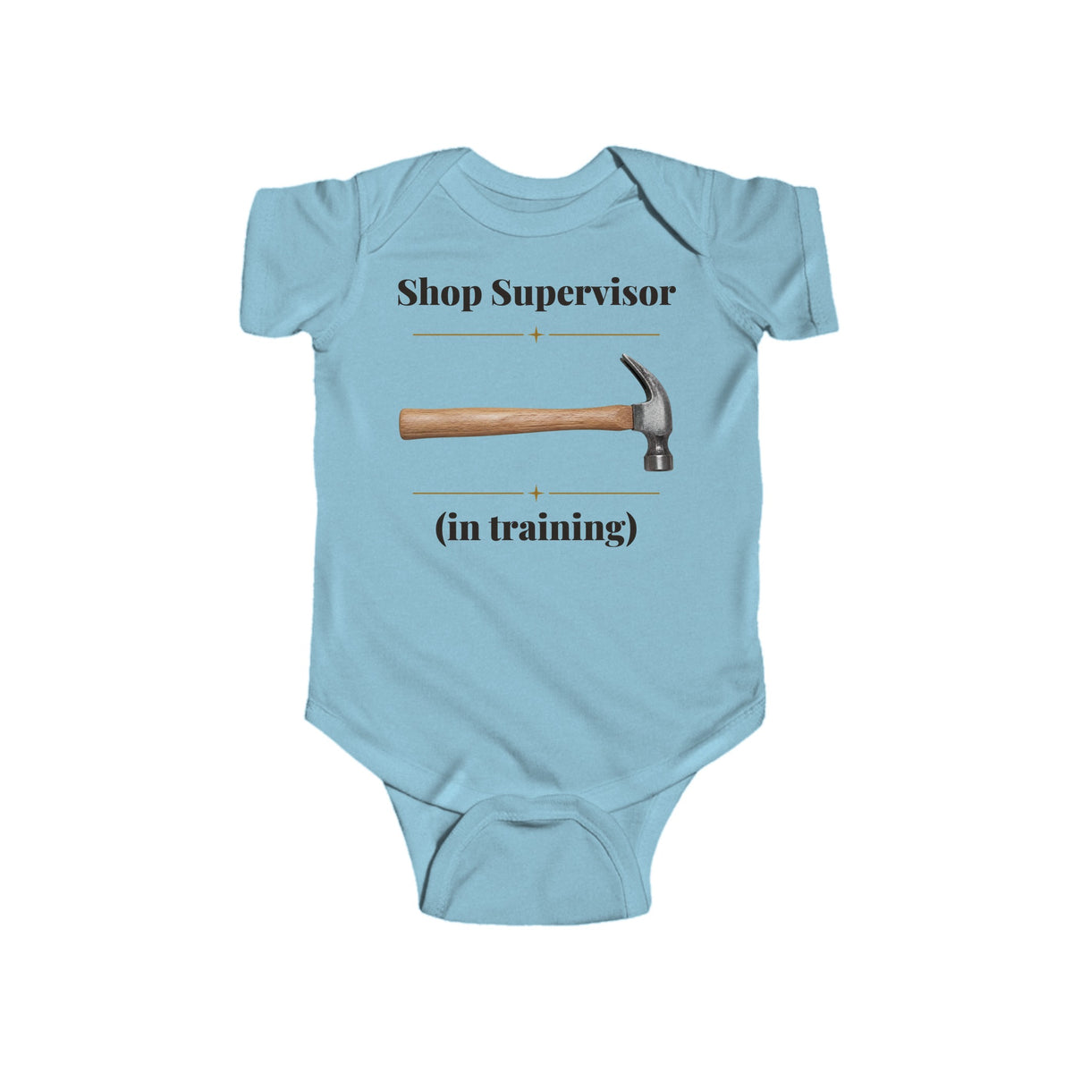 Shop Supervisor in Training baby bodysuit in Light Blue on a wood table with a knit blanket, wooden rattle and open Bible
