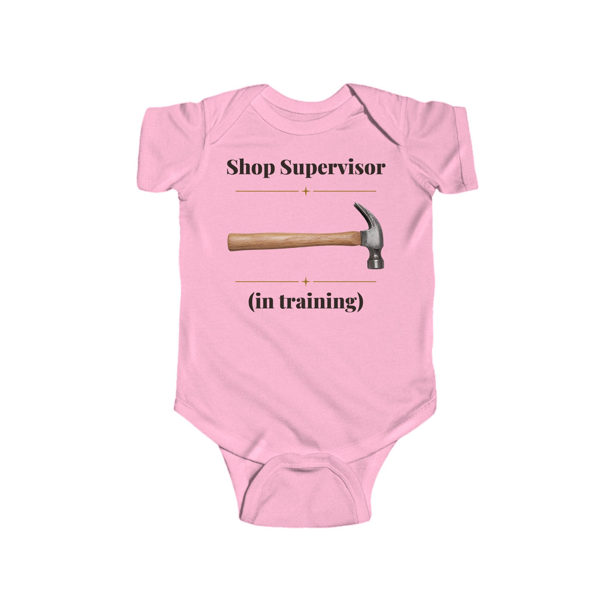 Shop Supervisor in Training baby bodysuit in Pink on a wood table with a knit blanket, wooden rattle and open Bible