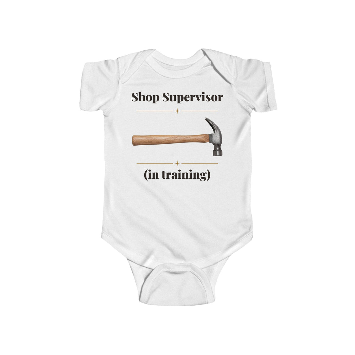 Shop Supervisor in Training baby bodysuit in White on a wood table with a knit blanket, wooden rattle and open Bible